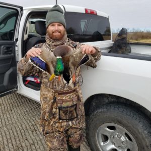 A happy guided hunter poses with his mallard duck on Lake Granger